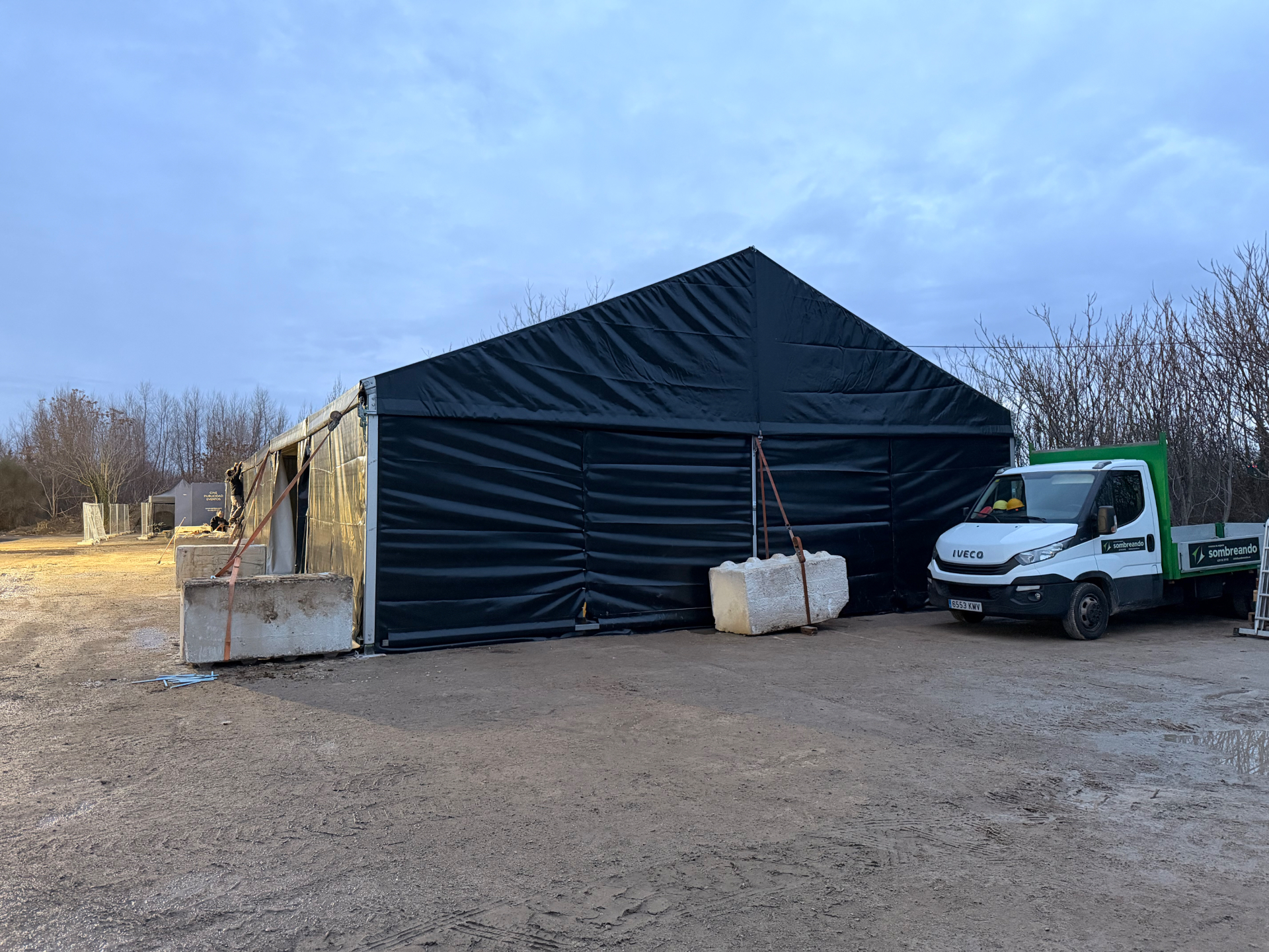 Instalación al atardecer con carpas y tarimas